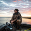 Duck hunter watching a sunset wearing the Waxed Canvas Jones Hat in brown, side view, from Dixie Decoys